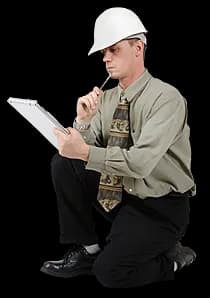 A builder in a hard hat kneeling with a clipboard.