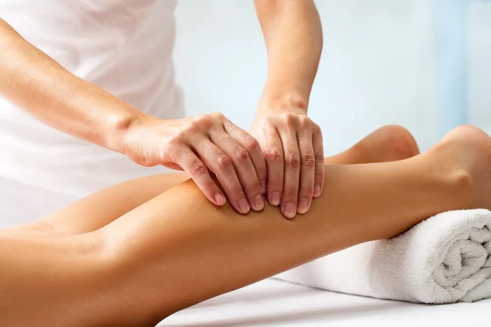 Massage therapist working on a patient’s calf muscle