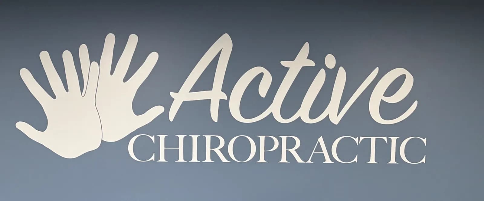 The Active Chiropractic sign, two white handprints beside the name, on the lobby wall.