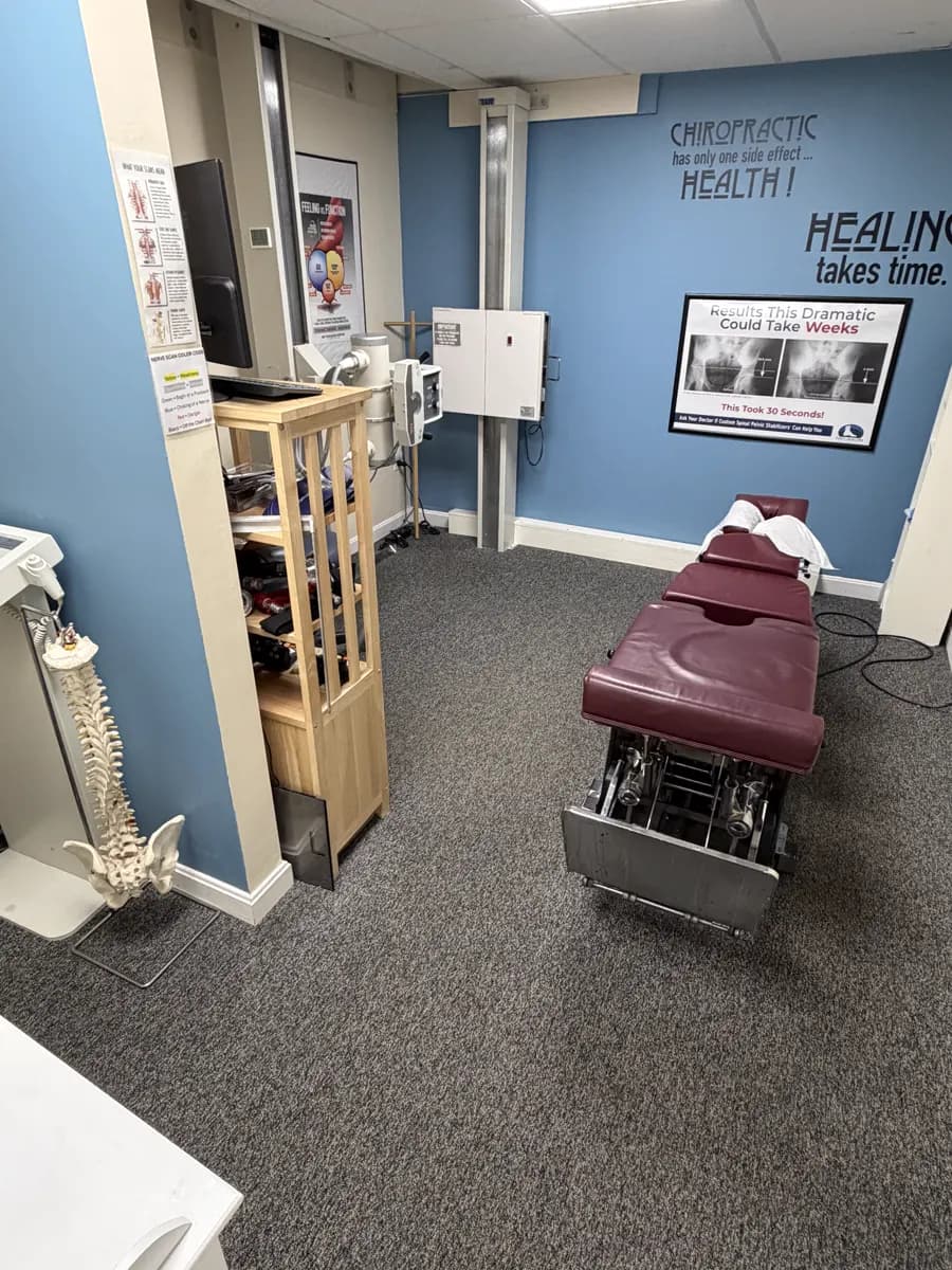 The X-ray room: the X-ray unit on the wall, an adjusting table and a model spine.